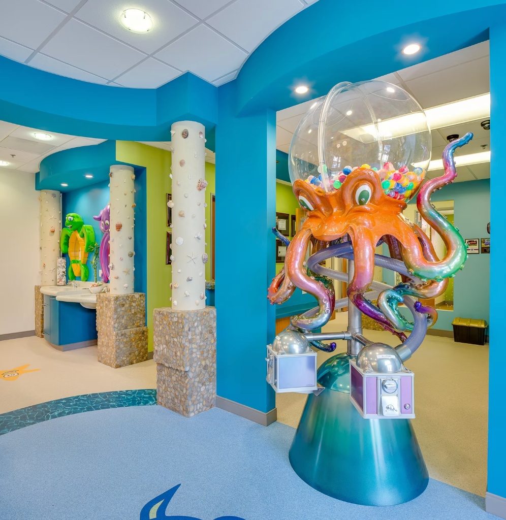 Kid-height brushing station sinks with sea-creature sculptures, off the main hallway
