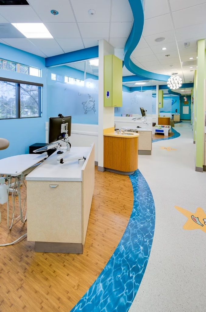 The open treatment bay at CarlsbaDDS Pediatric Smiles, an ocean ribbon winding through the floor