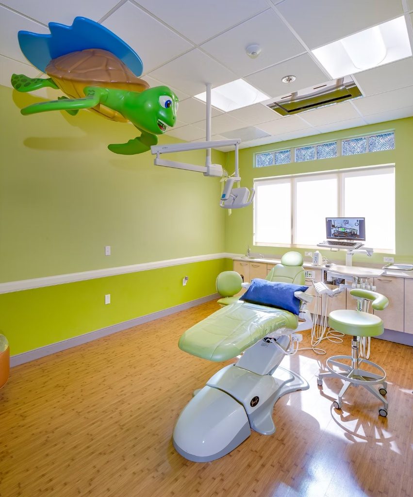 Private treatment room with soft green walls, real daylight, and a sea turtle sculpture overhead